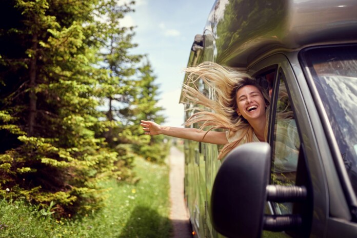 camper liberi itineranti salone del camper 2026 a parma - ragazza sorridente su camper in viaggio